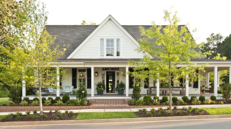 Front view of American styled white home with wrap around porch