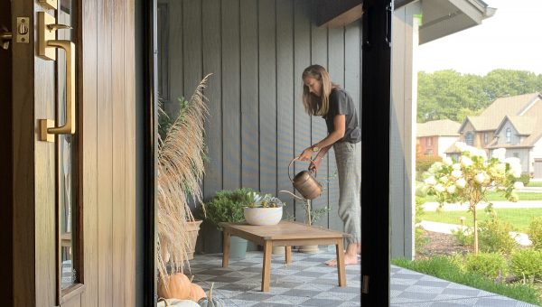 Woman waterung plants in front of retractable door screen