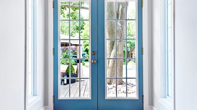 Blue French doors in country home leading to outdoor space